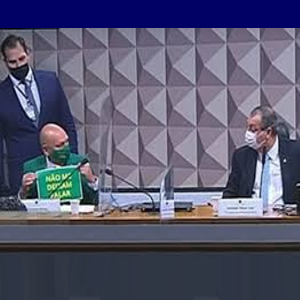 Luciano Hang mostrando uma de suas placas aos senadores da CPI